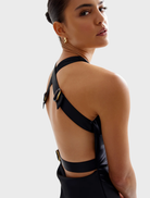 The Liora Dress, black and made of stretchy material, emphasizes a stylish and adaptable silhouette.