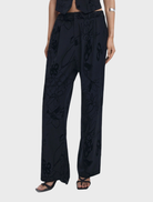 A pair of black long trousers laid flat, featuring a tailored fit and versatile style for both casual and formal wear.