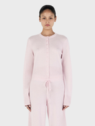 Blush Lucielle Cashmere Cardigan displayed on a hanger, showcasing its soft texture and elegant design.