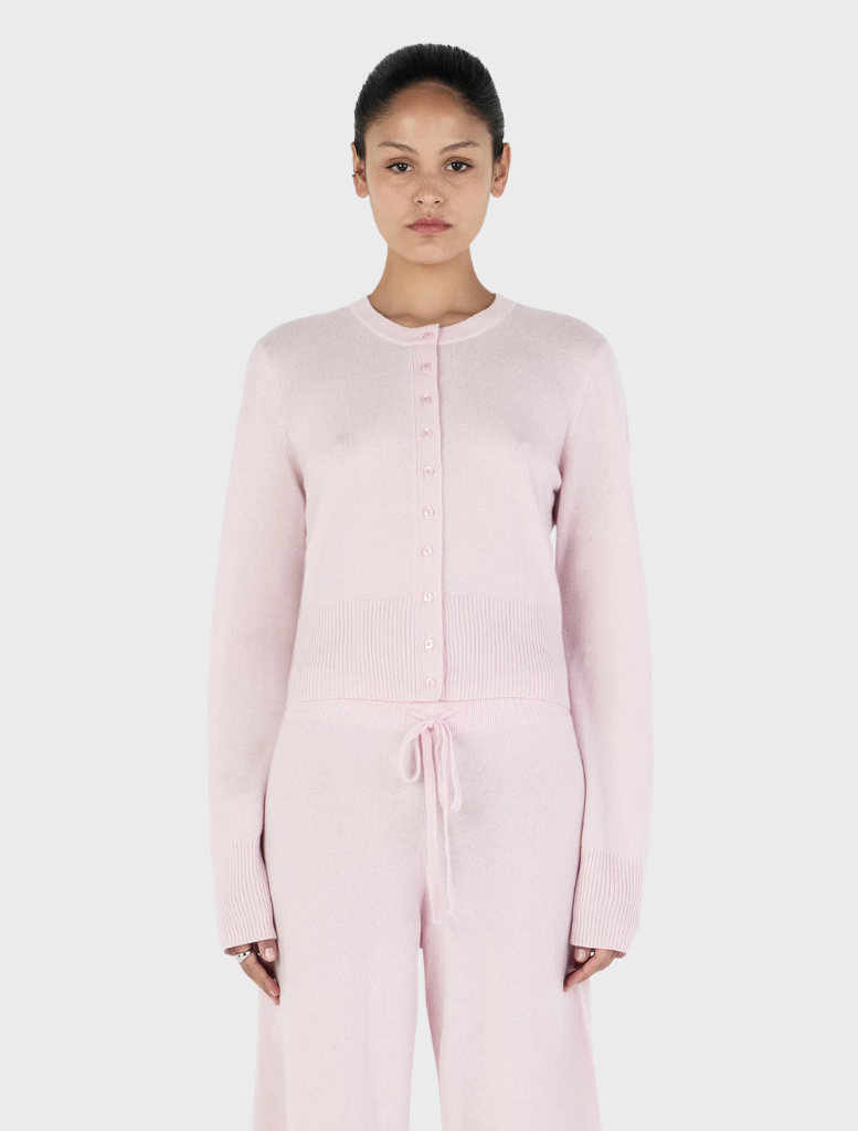 Blush Lucielle Cashmere Cardigan displayed on a hanger, showcasing its soft texture and elegant design.
