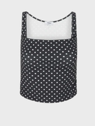Elegant black top adorned with small white dots, perfect for versatile styling options.