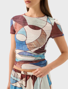 A woman in the Marley Mesh Tee - Playa, highlights its artistic abstract designs on a trendy t-shirt.