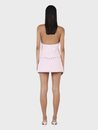 Trendy baby pink Nikita micro skort with stud accents, perfect for a fashionable summer look.