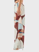 A woman dressed in the Miles Pant - Playa, highlighting a unique and eye-catching pattern.