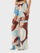 A woman models the Miles Pant in Playa, showcasing a vibrant, patterned design.