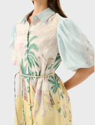 Model in the Berkley Mini Dress - Utopia, highlighting a cheerful design with palm trees and floral elements.