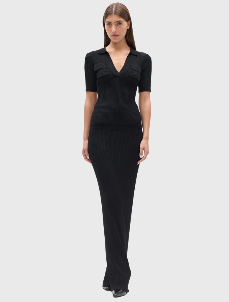 Black ribbed knit polo with a V neckline, short sleeves, and chest patch pockets featuring flap detailing.