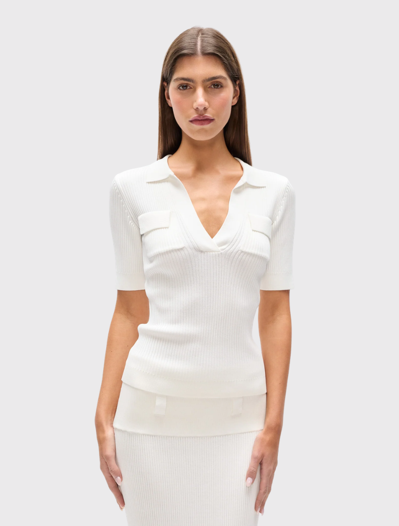 Ivory ribbed knit polo with a fitted shape, V neckline, short sleeves, and chest patch pockets with flap detailing.