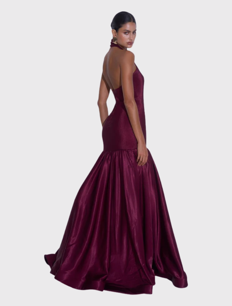 Wine-colored Montaigne Gown with a high halter neckline, elasticated fit, and flared skirt, combining structure and fluidity.