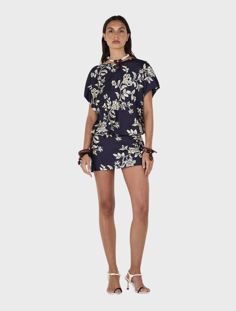 Model displays the Kodie Mini Dress, a navy and white floral design named Moonlit Vine.