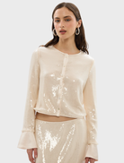 Pearl pink sequin top by Nadine, featuring a shimmering surface and a stylish design suitable for various occasions.