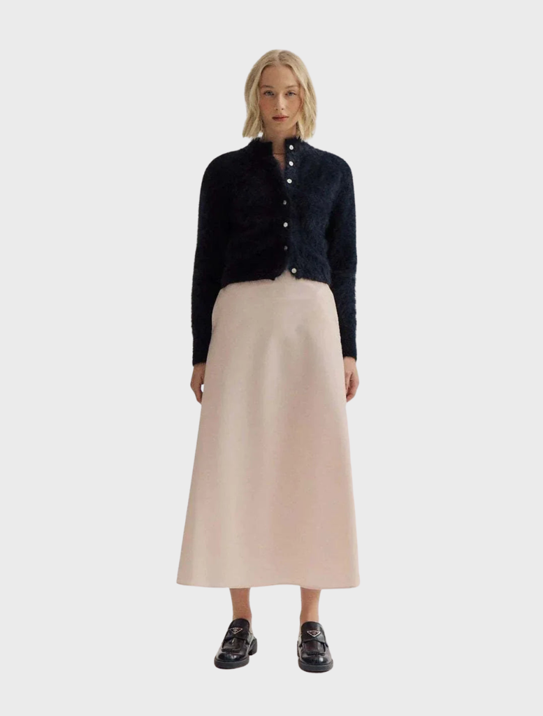 Elegant black Bella Cashmere Cardigan draped on a hanger, highlighting its luxurious fabric and classic style.