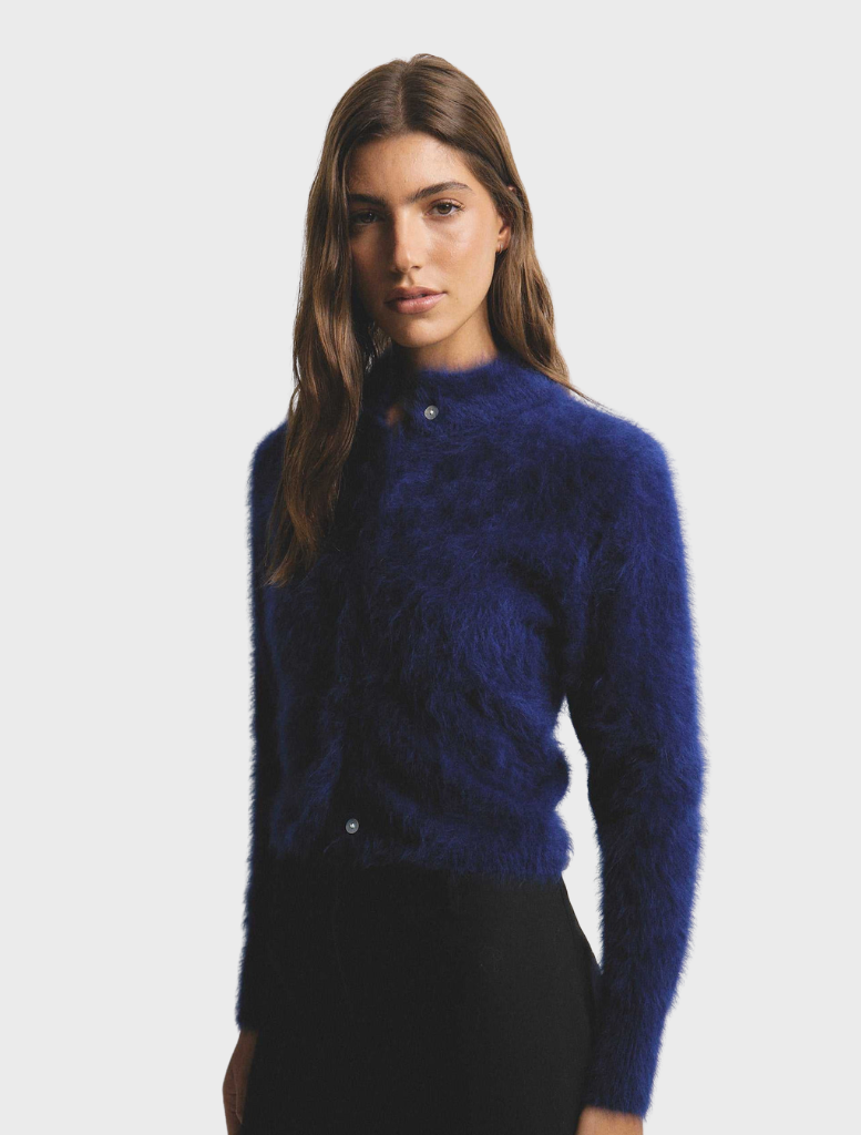 Elegant navy Bella Cashmere Cardigan draped on a hanger, highlighting its luxurious fabric and classic style.