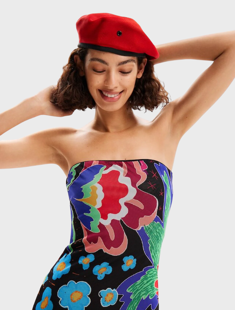 A neutral grey Swim Jungle Dress hanging on a rack, showcasing a lightweight fabric and vibrant jungle-themed design.
