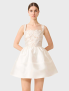 White and gold A-line mini dress with a fitted upper and flared lower, suitable for various occasions and stylish outings.
