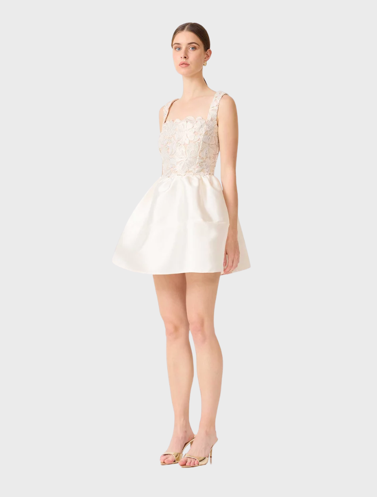 Elegant white A-line mini dress with gold accents, designed with a fitted top and a flowing skirt for a stylish look.