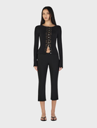 Black Nina Cardi Top displayed against a neutral background, illustrating its fashionable design and comfortable fit.