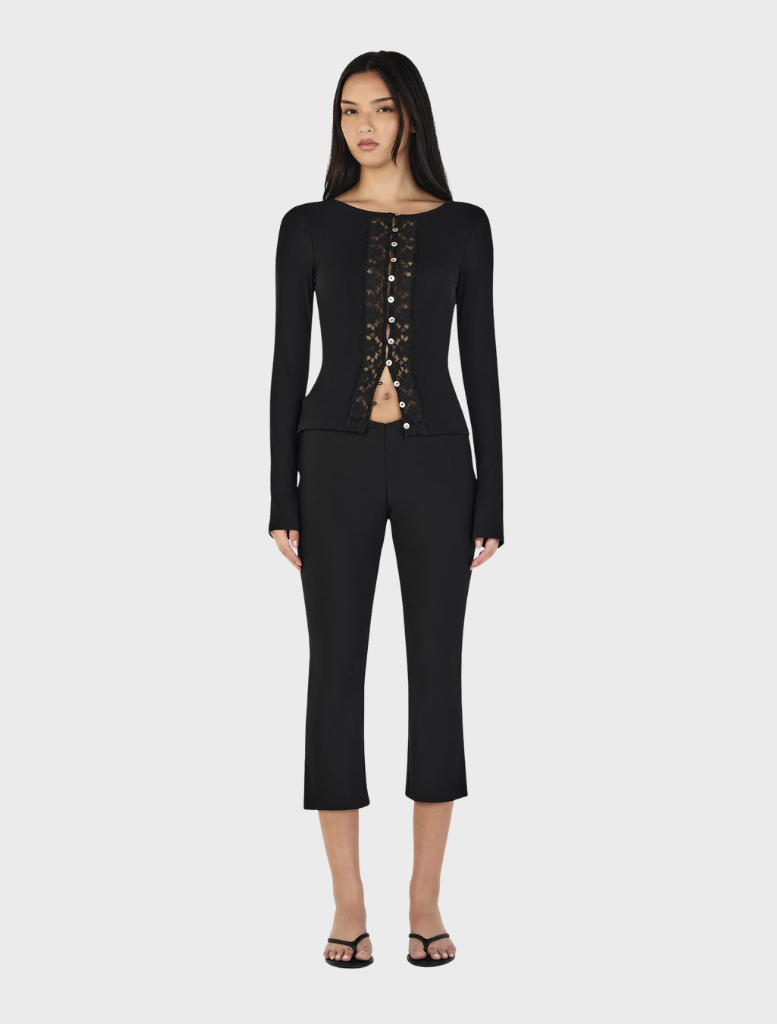 Black Nina Cardi Top displayed against a neutral background, illustrating its fashionable design and comfortable fit.