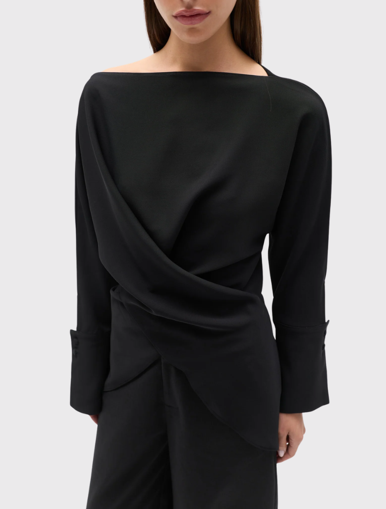 Black Novalyn Top showcasing a boat neckline, draped crossover, self-tie waist, relaxed fit, long sleeves, and wide cuffs.