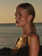 14k gold-plated OG Earrings adorned with clear crystals, inspired by the LOVE DRUG PILL necklace, benefiting GIRLS Inc.