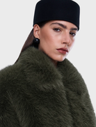 Olive faux fur bomber jacket with oversized fit, standard collar, front zipper, side pockets, and elasticated hem and cuffs.