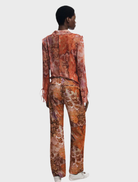 A pair of long orange trousers laid flat, highlighting their bright color and casual design suitable for various occasions.