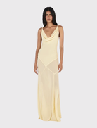 Butter yellow gown with a cowl neckline, twist strap accents, and a flowing bias-cut skirt for a relaxed yet elegant look.
