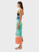 A woman dressed in a colorful floral dress stands out with its bright and cheerful flower patterns.