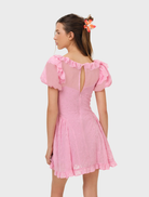 Elegant pink mini dress with eyelet design, perfect for summer outings, featuring a flared skirt and stylish details.