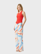 Pippi Tank Top in Poppy, designed with a scoop neckline, racerback, and delicate lace trim for an elevated resort wardrobe.