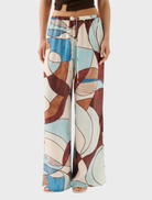  woman wearing the Miles Pant in Playa, featuring a colorful and stylish pattern.