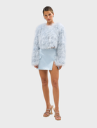 Powder blue Manhattan Crop Jacket made of marabou feathers, featuring structured shoulders and a feminine cropped design.