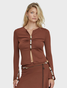Espresso-colored Prism blouse displayed on a hanger, showcasing its elegant design and fabric texture.