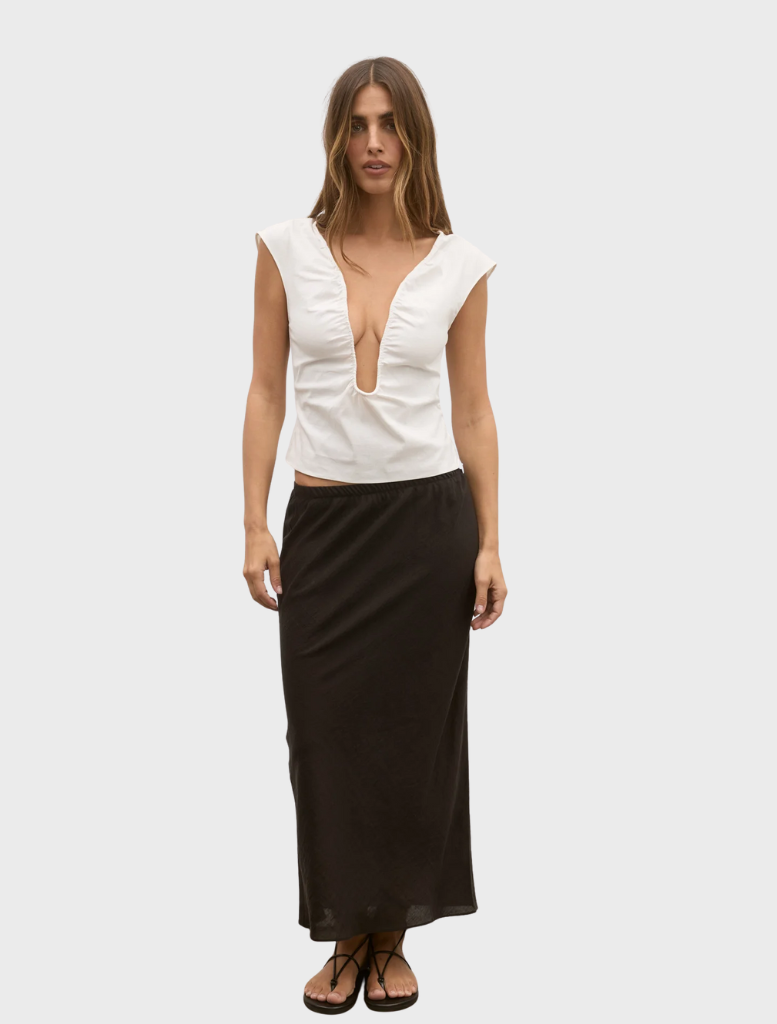 White Rani top laid flat, emphasizing its clean lines and modern design, perfect for layering or standalone wear.