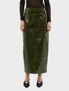 A khaki Raye maxi skirt hanging on a rack, featuring a long, flowing style suitable for various occasions.