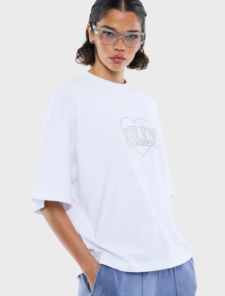 White tee with a bold rhinestone logo, combining elegance and casual style.