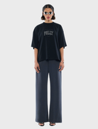 Elegant black tee with a decorative rhinestone logo, suitable for both casual and dressy settings.