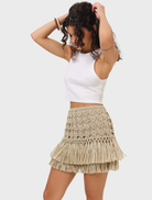 The Riley Raffia Skirt in natural color, elegantly draped to emphasize its soft texture and relaxed fit.