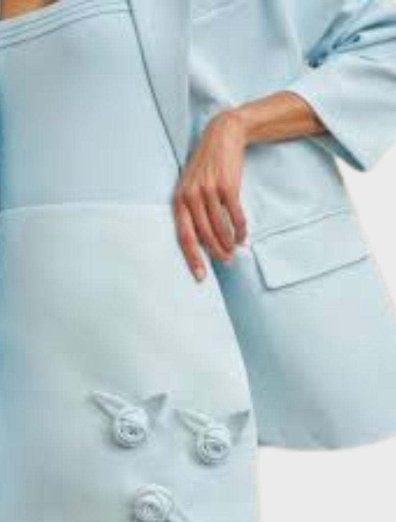 A-line mini skirt in ice blue with decorative handmade rosettes, made from structured twill and fully lined for comfort.