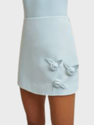 Ice blue A-line mini skirt with carefully placed handmade rosettes, made from structured twill weave and fully lined.