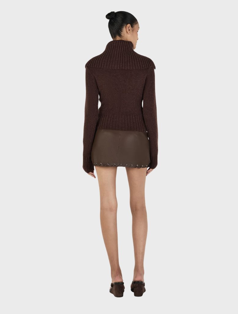 A chocolate turtleneck sweater named Roxanne, featuring a snug fit and elegant design, set against a plain backdrop.