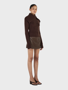 Chocolate Roxanne turtleneck sweater, emphasizing its stylish fit and cozy fabric, displayed on a light-colored surface.