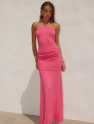 Vibrant hot pink halter maxi dress with ruched accents, designed for a chic and comfortable summer look.