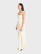 The Samara gown in butter showcases a graceful design with a light, airy fabric perfect for formal occasions.
