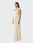 Samara gown in a warm butter hue, characterized by its elegant lines and soft, flowing fabric ideal for special events.