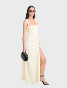Elegant Samara gown in a soft butter color, featuring a flowing silhouette and delicate fabric draping.