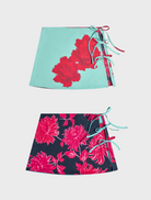 Two skirts featuring vibrant pink and blue floral patterns displayed side by side.