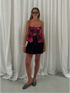 A woman in a vibrant floral dress showcasing her joyful demeanor.