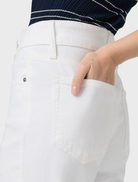 A woman in white wide-leg jeans and a striped top, representing the Sasha 32 style in a chic outfit.