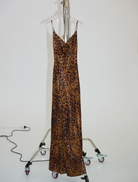 Stylish leopard print gown featuring a rosette detail, perfect for formal occasions and evening events.
